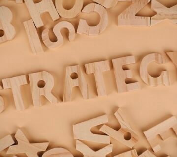 صورة تصور كلمة "STRATEGY" وسط أحرف خشبية متناثرة، تعكس تطوير استراتيجيات تدريب مبتكرة للقيادة الخيرية 